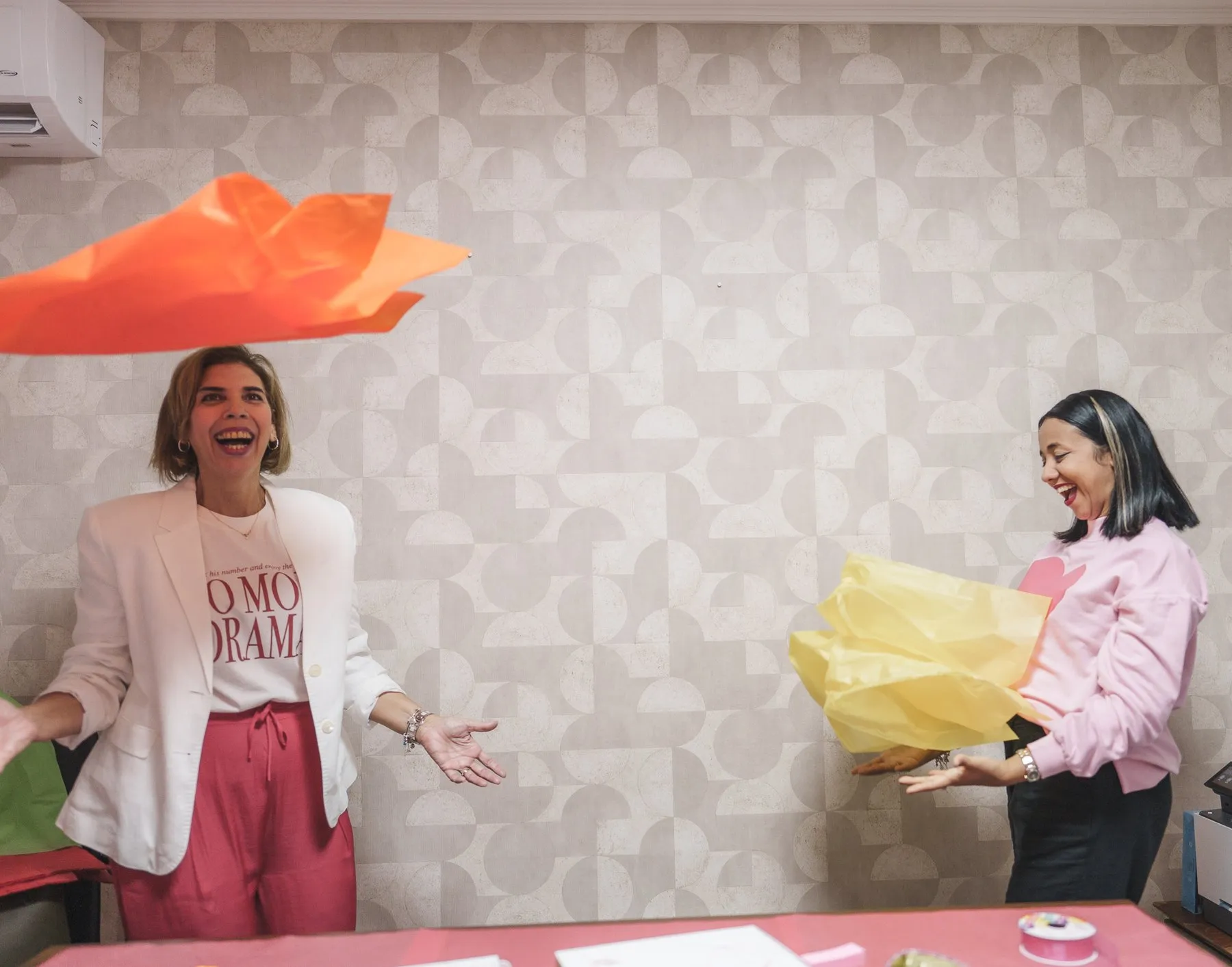 Niky y Lindsey riéndose mientras lanzan papel de seda